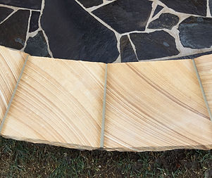 Crazy paving firepit with raised sandstone seatig area
