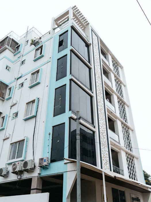 Tall white and blue building with multiple floors and large windows