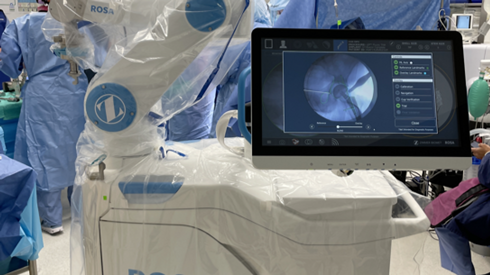 Eye-level view of a surgical team performing robotic-assisted knee replacement
