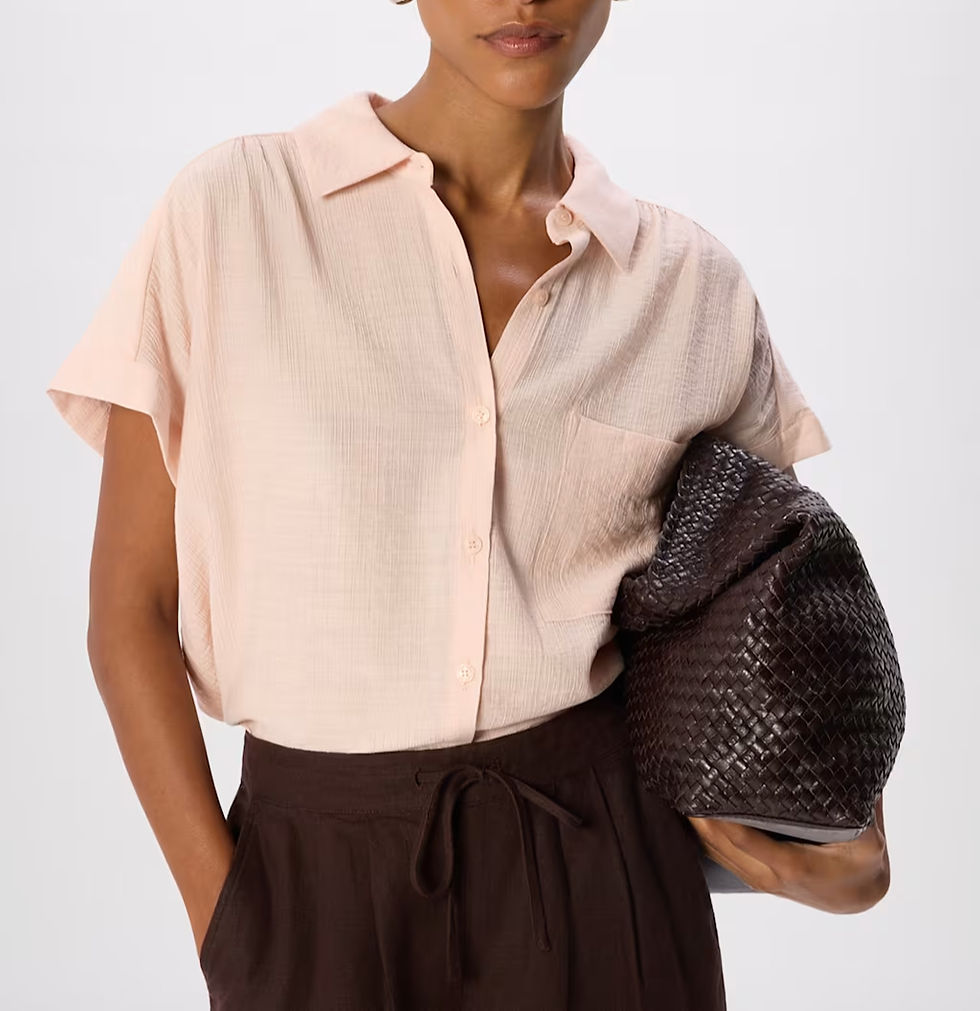 woman wearing a shirt and trousers holding a weave bag 