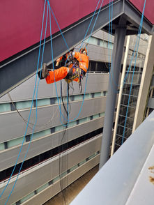 Worker rappelling on building exterior