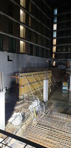 Partially built structure at night with scaffolding and rebar reinforcement.