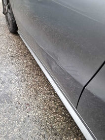 dent on side of silver car