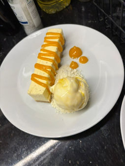 Slices of cake with mango sauce and ice cream