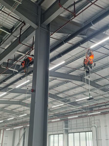 Two workers in safety vests on high steel beams
