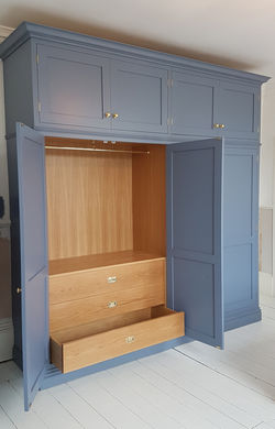 Blue fitted wardrobe with built-in dressing area.