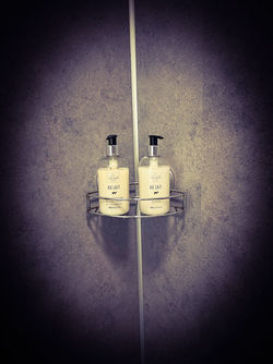Set of luxury toiletries mounted on a dark wall.