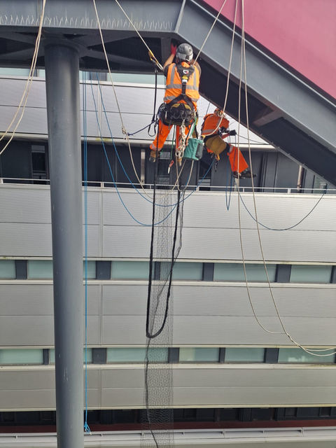 Construction worker suspended on building facade