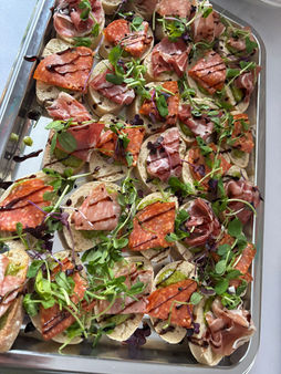 Tray of small appetizers with cured meat and greens