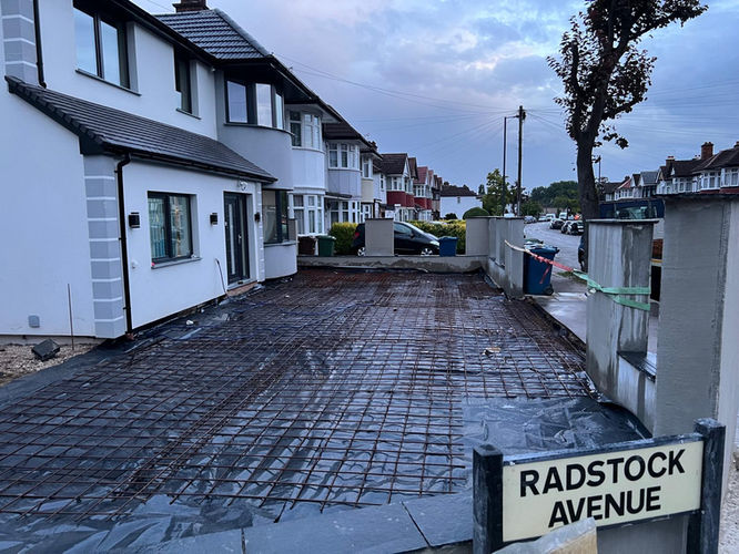 Home exterior with driveway under construction, reinforced with steel mesh.