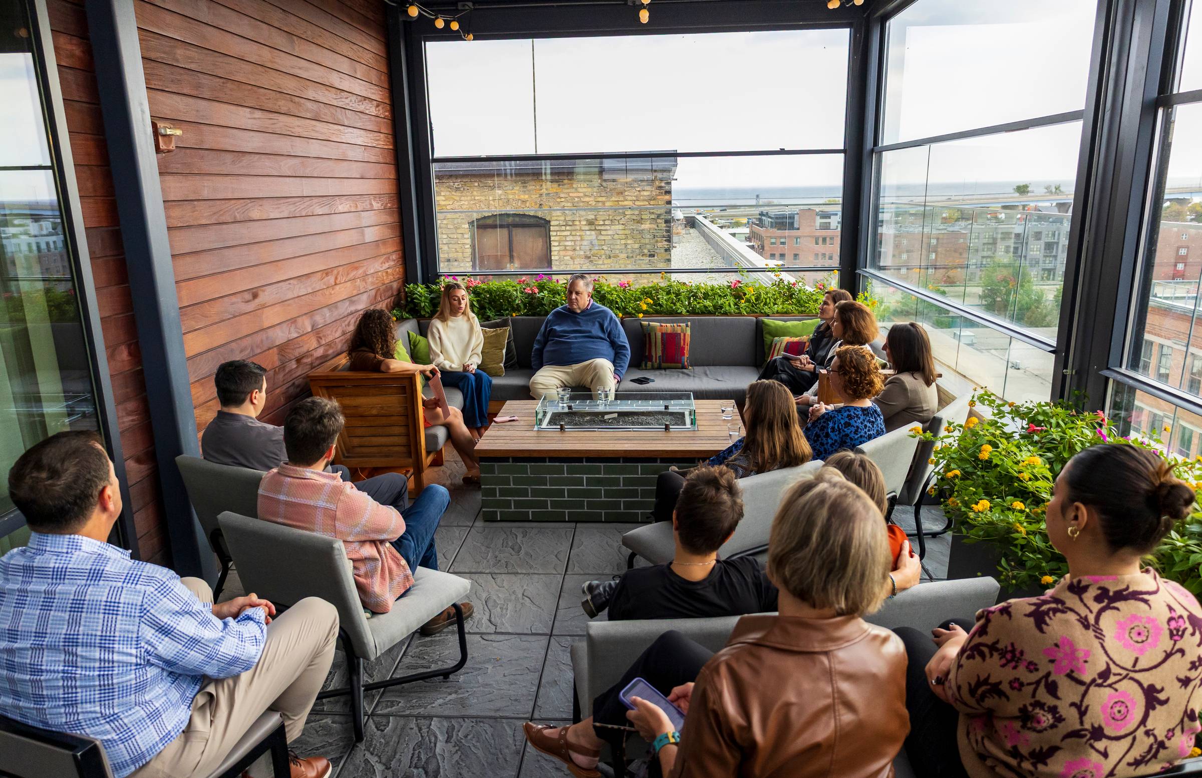 A group of professionals sitting in a semi circle at a gathering, listening to a panel discussion