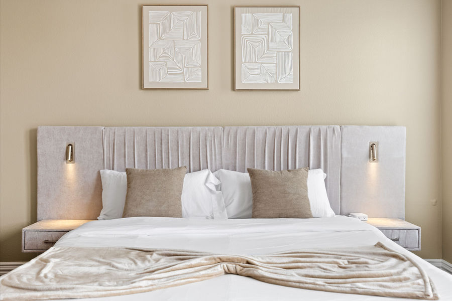 Styled bedroom with upholstered headboard: Houston real estate photography by Marz Media Photography