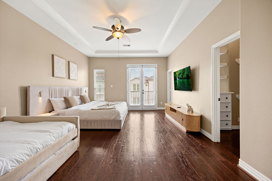 Bedroom with wood flooring and natural light: luxury real estate photography in Houston, TX by Marz Media Photography