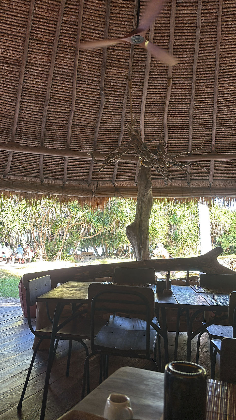 Open-air dining area at Nautilus restaurant on Gili Asahan with thatched roof and ocean views