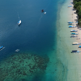 Aerial view of Gili Asahan beach with traditional fishing boats in clear water