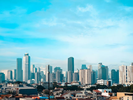 Daytime skyline of Jakarta showing the city's central business district towers rising above a dense urban foreground, representing Indonesia's capital market ambitions at a moment when three major global index providers are simultaneously questioning the transparency of its equity markets.