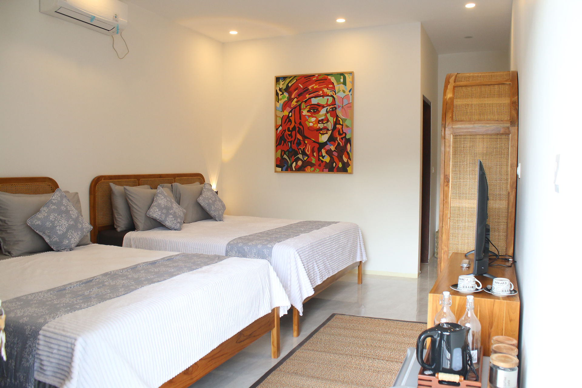  Twin bedroom at DHM Surf Camp Kuta Lombok with wooden furniture, local artwork, and natural light