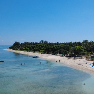 Aerial view of Gili Air coastline with clear water and fishing boats offshore