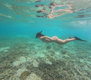 Snorkeler swimming above the coral on Gili Islands
