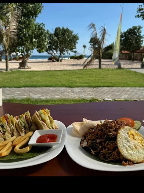 Club sandwich with fries and mie goreng with a fried egg served on banana leaf plates at Nine Dining and Resto, Serangan Beach, Lombok