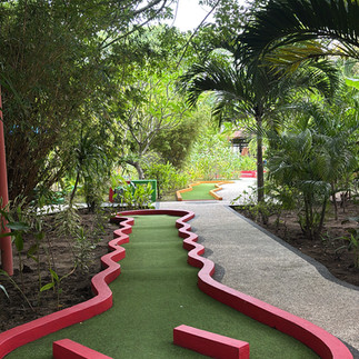 Mini golf course with bright red borders surrounded by tropical plants on Gili Trawangan.