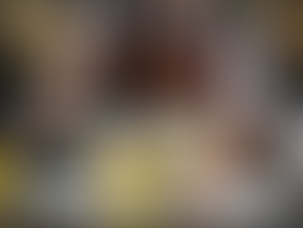 A bartender in a leather apron uses a sous vide immersion circulator to prepare infusions in a water bath filled with vacuum-sealed bags of citrus peels, herbs, and spices on an illuminated bar counter. Fresh fruit and glass lab equipment, including beakers and flasks, are arranged around the setup.