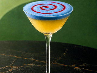 CHROMA cocktail with blue foam and red roselle spiral