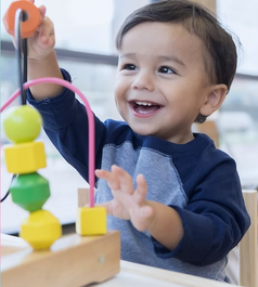 little boy laughing, playing with a sorting toy