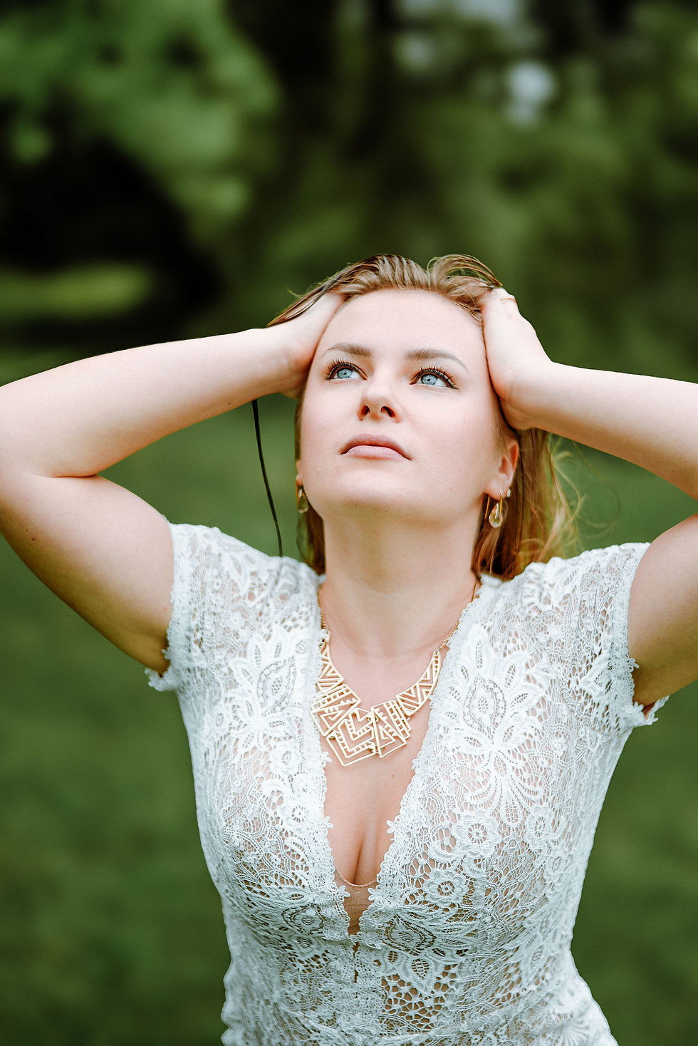 Woman in white lace dress seeking wellness outdoors.