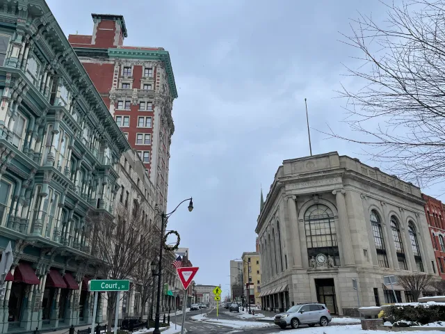 Winter scene on Court Street in downtown Binghamton, NY, with historic buildings and light snow