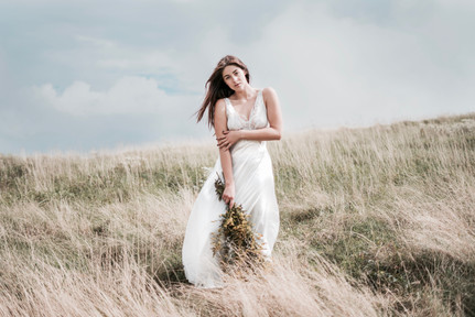 on grassy hill hair blown.jpeg