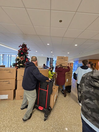 Volunteers of all ages work together to deliver toys, brightening the day for patients and staff.