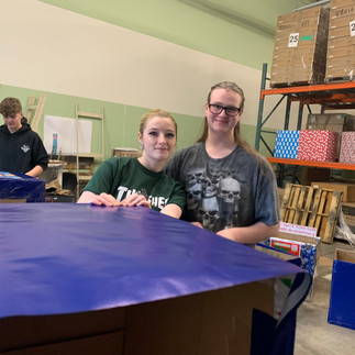 The sound of tape and laughter fills the air as the Kidzz Helping Kidzz Advisory Board preps food drive boxes