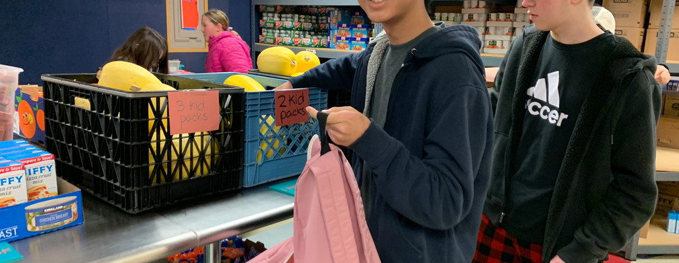 Volunteer's thumbs up encouraging others to participate in the kidzz helping kidzz food drive.
