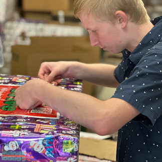 Kidzz Helping Kidzz volunteers prepare for their toy drive by decorating collection boxes with festive cheer
