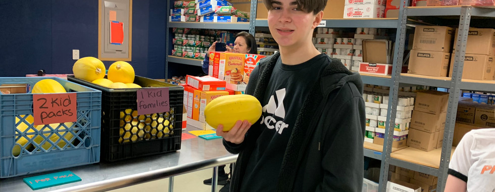 Child surprised and delighted to find a book in a kidzz helping kidzz food box, addressing needs beyond hunger.