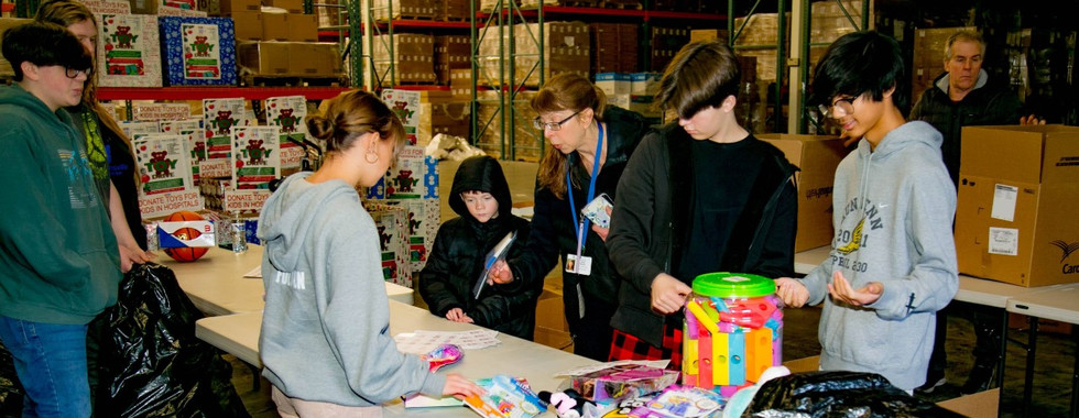 Volunteers for Kidzz Helping Kidzz communicating in an assembly line structure.
