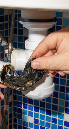The plumber removes the blockage in the 