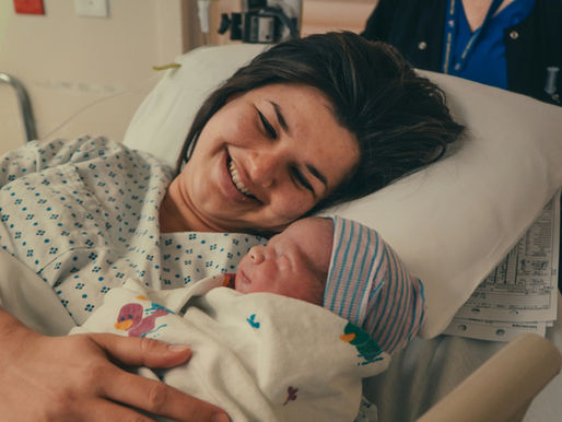 New mom holding her newborn baby in a hospital bed