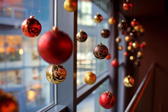 Ventana decorada con bolas navideñas en color rojo.
