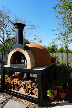 Orange Woodfired Co 850 brick face pizza oven on a custom black stainless steel stand with concrete bench top, built and finished by Brisbane Pizza Ovens.
