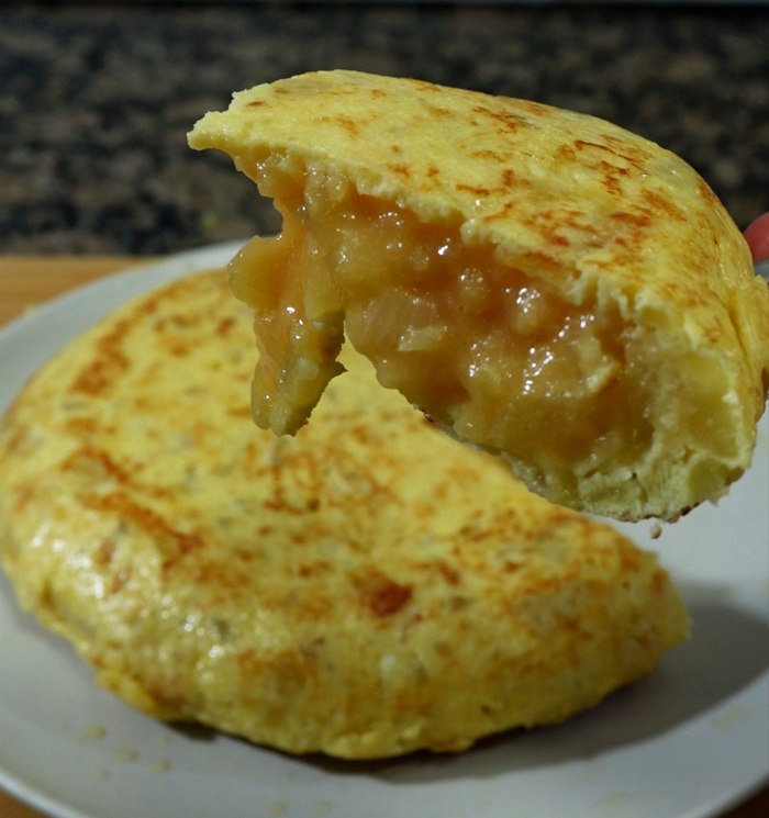 Foto cerca de la tortilla donde se puede ver el punto de cocción que la deja jugosa y muy sabrosa. 