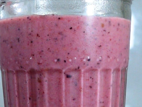 Foto de un vaso que contiene un batido de color rosa