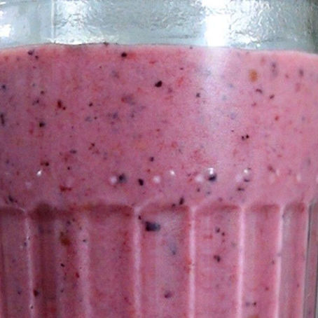 Foto de un vaso que contiene un batido de color rosa