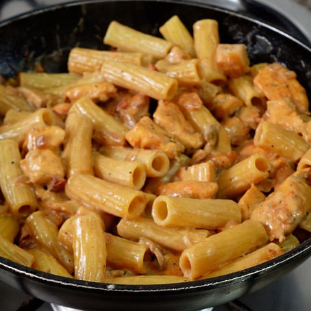 Foto detalle de la pasta con la salsa aún en la sartén
