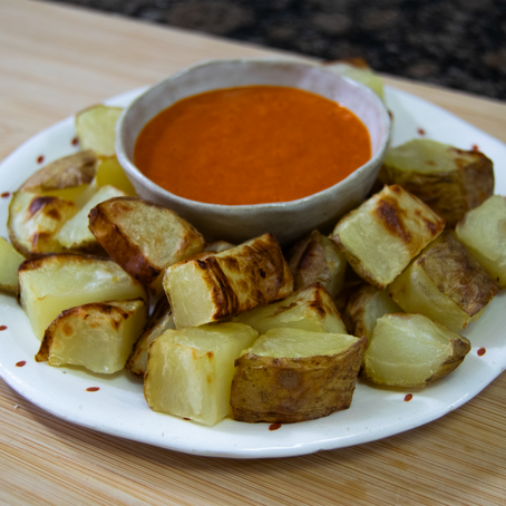 Foto de unas patatas bravas caseras con su salsa con un toque picante. 