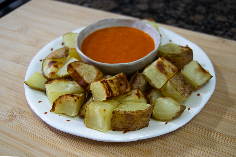 Foto de unas patatas bravas caseras con su salsa con un toque picante. 
