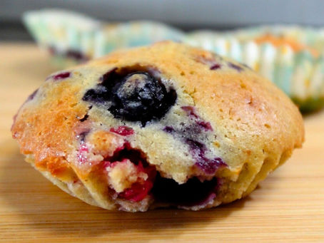Foto cercana de un muffin, en el que se ve un arándano grande en primer plano