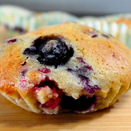 Foto cercana de un muffin, en el que se ve un arándano grande en primer plano