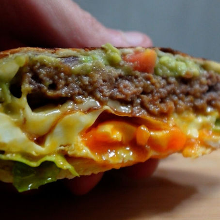 Foto detalle del wrap visto desde delante, se ve (de arriba a abajo) la capa de guacamole, carne picada, queso, huevo y lechuga